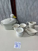 group shot of ceramic duck casserole, mugs, creamer, gravy boat and container
