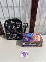 Overall lot showing Mickey backpack and stacked Disney VHS tapes