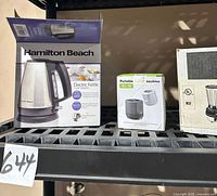 Shelf view showing boxed kettle, portable sealer box, and blender carton