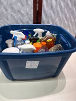 Blue bin containing assorted cleaners and accessories