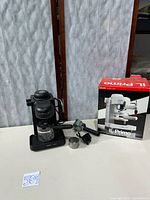 Espresso machine, carafe, portafilter, scoop, box displayed