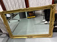Front view of ornate gold framed wall mirror