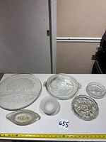 All six glass serveware pieces arranged on table with measuring tape