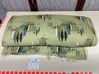 Rolled bolt of green mid-century fabric showing pattern and width
