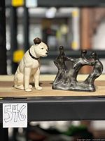 RCA dog figurine next to abstract dancing trio sculpture