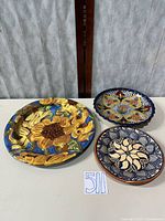 Three ceramic plates displayed together
