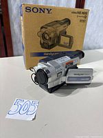 Camcorder placed in front of original Sony box with lot number visible