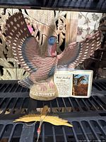 Front view of ceramic Wild Turkey decanter with booklet and fiber bird in foreground
