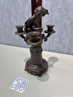 Full view of bronze cherub candelabra showing three candle cups and overall form