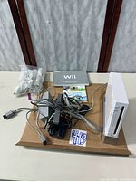 Overall lot: Wii console, cords, controllers bag, manuals, game