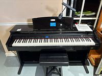 Front view of Williams Overture 2 digital piano with bench and lamp