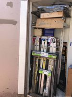 View of storage unit showing three folding ladders and accessories