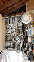 Overall view of pegboard wall filled with numerous metal locking clamps and pliers