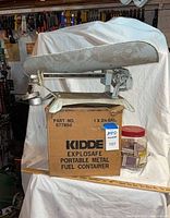 Detecto scale resting on Kidde fuel container box with jar of matchbooks beside