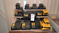 Front view of all DeWalt chargers and batteries on wooden shelf
