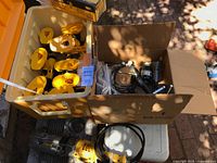 Top view of tote with multiple yellow DeWalt cordless drill bodies and box of grips