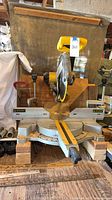 Front view of DeWalt sliding compound miter saw on wooden stand
