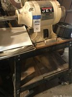 Overall view of JET sanding/buffer machine on metal stand with accessories