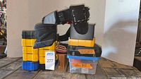 Stacked DeWalt bit cases, tool belt atop, labeled small boxes