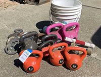 Group shot showing kettlebells, plates, dumbbells, bucket