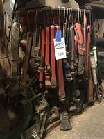 Cluster of large pipe wrenches hanging on hooks with other heavy tools