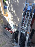 Overall lot showing toolbox, jack stands inside, ramps, cart, traction mats