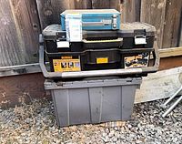 Makita case on DeWalt toolbox over grey tote