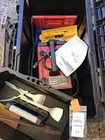 Tools and accessories inside black tote including welder, pliers, spatula, manuals