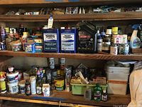 Shelves filled with solvent cans, motor oil jug, aerosol cleaners and paint supplies
