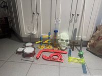 All items laid out: skull mask, three swords, marble run parts, two red drums