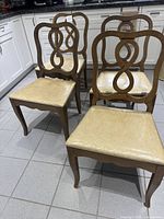 Four wood dining chairs grouped in kitchen