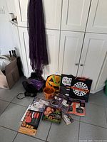 Group shot of all Halloween items on floor including costume pieces, pail, treat bags, carving kit and décor