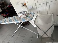 Ironing board, boxed Black+Decker iron, IKEA hamper overview