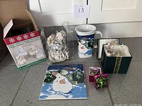 All items grouped: music box in original open carton, mug, trivets, ornament, gift boxes