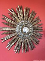 Full view of sunburst wall mirror against red wall