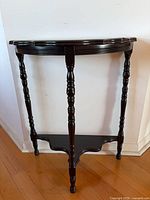 Front view of dark wood demilune console table showing overall design