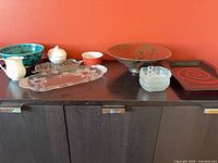 group shot of all 11 serveware pieces on cabinet