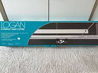 Front of teal retail box showing Logan Compact Mat Cutter image