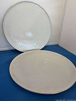 Two white porcelain dinner plates with embossed rim and gold edge