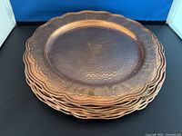 Stack of scalloped hammered copper charger plates