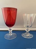 Side-by-side red and clear goblets showing shape and stem detail