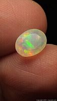 Front view of oval faceted opal showing play-of-colour