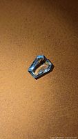 Fancy cut blue aquamarine gemstone on brown surface