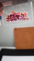 Bag of small multicolor rough sapphire crystals backlit to show color