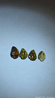 Four leaf-cut tourmaline gemstones lined up on white background