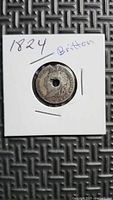 Obverse of 1824 British coin in flip showing drilled hole and bust design