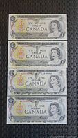 All four 1973 $1 Bank of Canada notes displayed