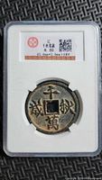 Front of encapsulated Chinese coin showing obverse inscription and grading label