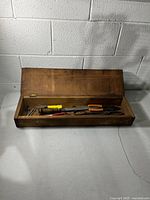 Wooden toolbox open with tools inside, overview