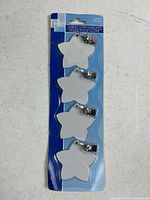 Front of blister card showing four star tablecloth weights